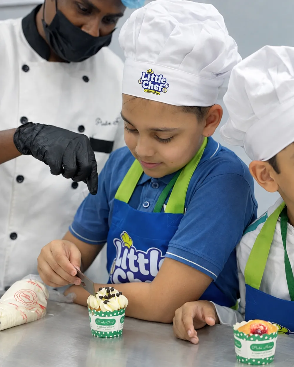 A Little Chef decorating a cupcake with a Pista House chef